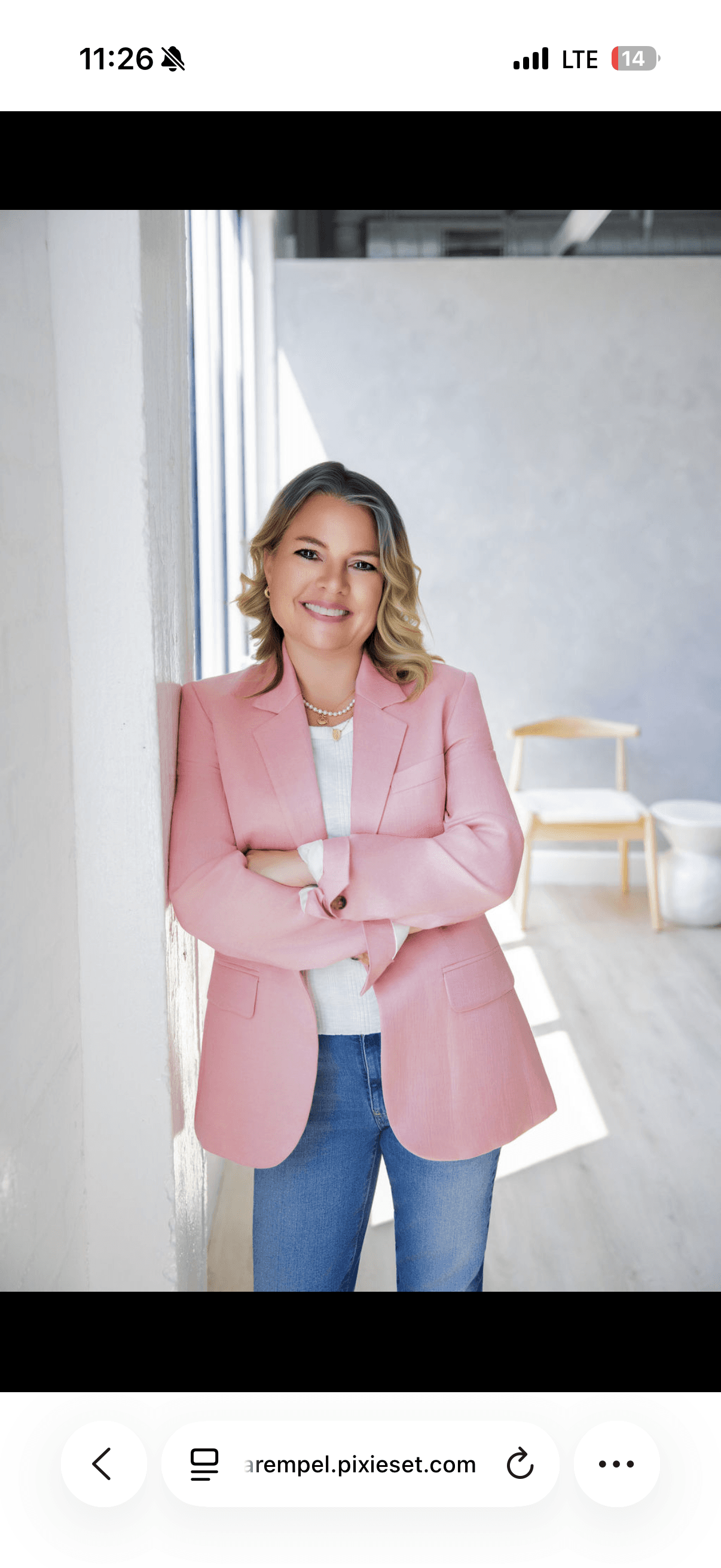 Professional headshot of a business owner wearing a pink blazer